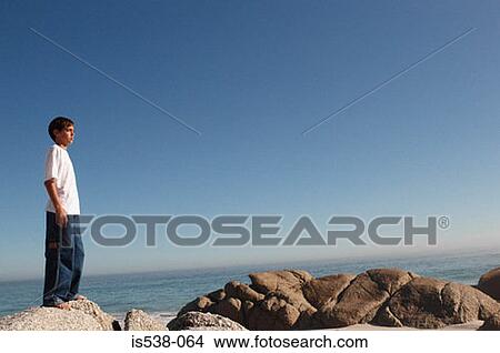 Young boy looking at the sea View Large Photo Image Picture - Young boy looking at the sea. Fotosearch