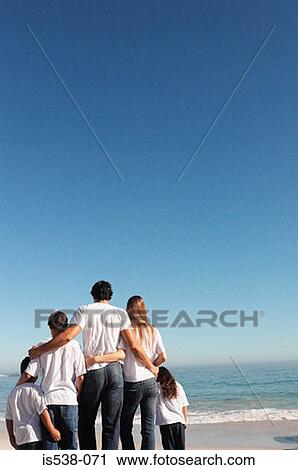 Stock Image - Young family on a beach. Fotosearch
