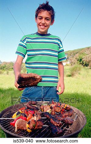 Boy cooking meat on barbeque View Large Photo Image Stock Image - Boy cooking meat on barbeque. Fotosearch
