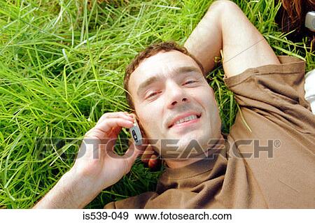 Man using mobile phone in field View Large Photo Image Stock Photo - Man using mobile phone in field. Fotosearch
