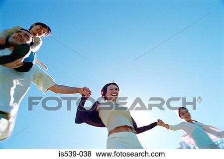 Stock Photo - Smiling family holding hands. Fotosearch