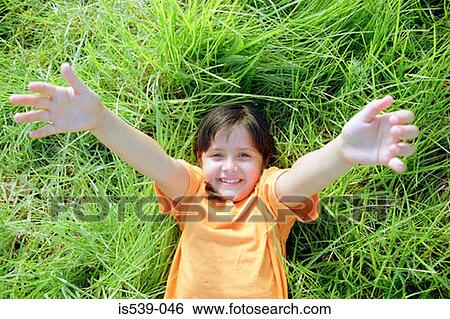 Smiling girl lying on grass View Large Photo Image Stock Photograph - Smiling girl lying on grass. Fotosearch