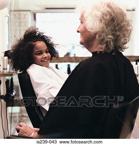Stock Image - Woman and girl in hairdressers. Fotosearch