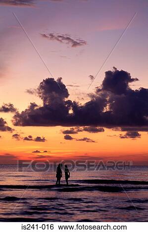 Couple in sea at sunset View Large Photo Image Stock Photograph - Couple in sea at sunset. Fotosearch