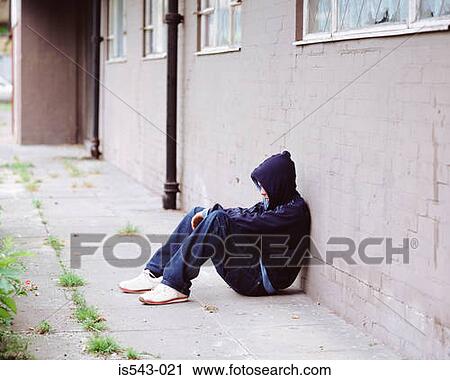 Teenage boy sitting against wall View Large Photo Image Stock Image - Teenage boy sitting against wall. Fotosearch