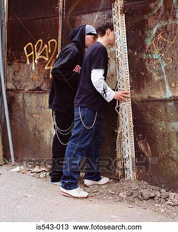 Teenage boys peering through wall View Large Photo Image Stock Image - Teenage boys peering through wall. Fotosearch