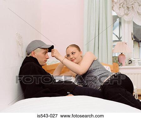 Teenage couple on bed View Large Photo Image Stock Photo - Teenage couple on bed. Fotosearch