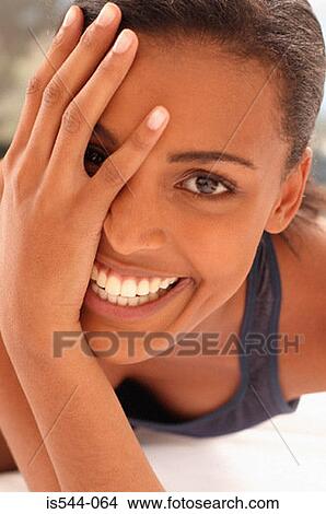 Smiling young woman partially covering face View Large Photo Image Picture - Smiling young woman partially covering face. Fotosearch