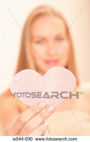 Stock Image - Woman holding pink heart. Fotosearch
