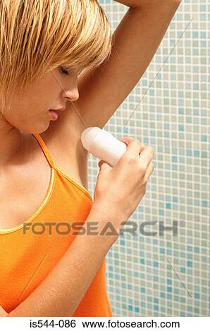 Young woman applying deodorant View Large Photo Image Stock Photograph - Young woman applying deodorant. Fotosearch