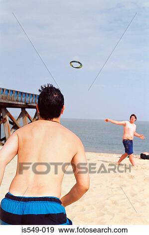 Stock Photo - Boys playing quoits on the beach. Fotosearch