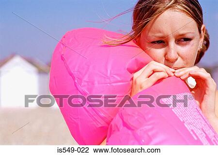 Girl blowing an inflatable lifebelt View Large Photo Image Stock Image - Girl blowing an inflatable lifebelt. Fotosearch