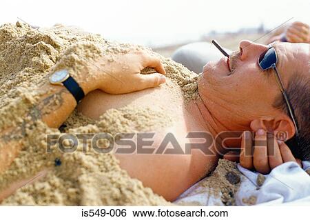 Man covered in sand View Large Photo Image Stock Photograph - Man covered in sand. Fotosearch