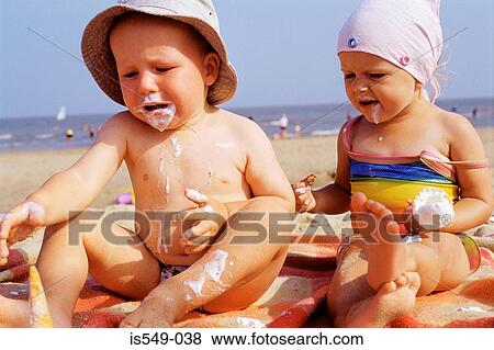 Toddlers having ice cream on the beach View Large Photo Image Stock Photo - Toddlers having ice cream on the beach . Fotosearch