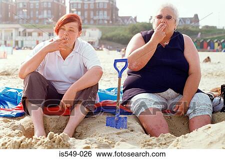 Two women smoking on the beach View Large Photo Image Stock Photograph - Two women smoking on the beach. Fotosearch