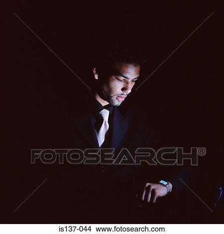 Picture - Businessman looking at watch. Fotosearch