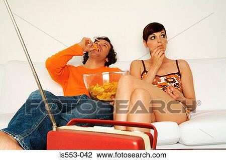 Couple at home eating crisps View Large Photo Image Stock Image - Couple at home eating crisps. Fotosearch