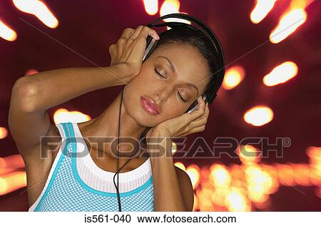 Stock Image - Asian woman wearing headphones. Fotosearch