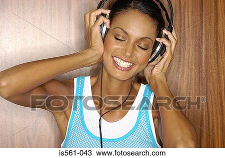 Stock Image - Asian woman wearing headphones. Fotosearch