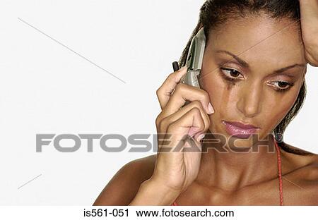 Stock Image - Crying woman using cellular telephone. Fotosearch