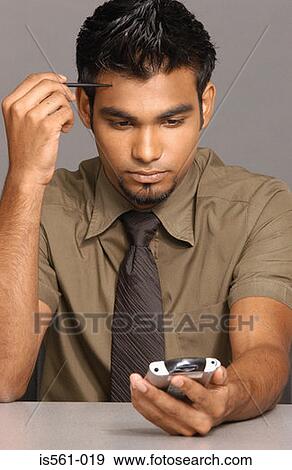 Stock Photo - Man using handheld computer. Fotosearch