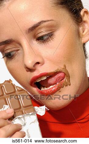 Picture - Young woman eating chocolate. Fotosearch