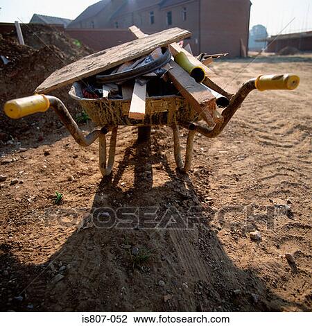 Stock Image - Wheelbarrow with building waste. Fotosearch