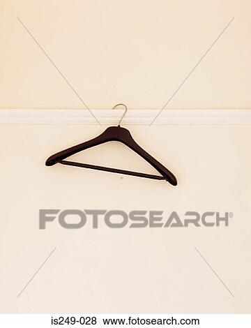 Stock Photo - Empty hanger hanging on wall. Fotosearch