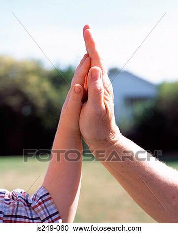 Stock Image - Hand of man and boy touching. Fotosearch