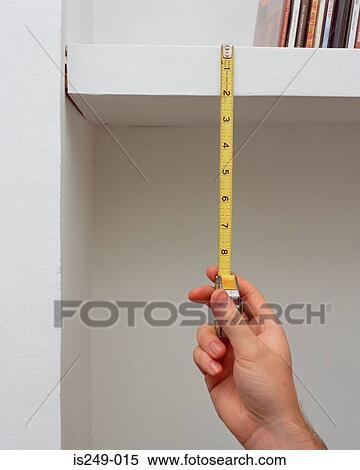 Stock Photography - Measuring shelf height. Fotosearch