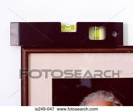 Stock Photo - Spirit level on picture frame. Fotosearch