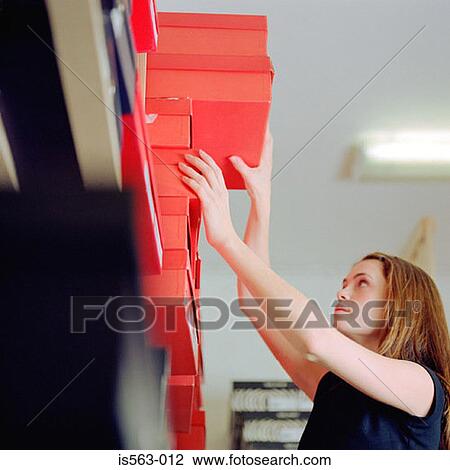 Stock Image - Woman reaching for shoe box. Fotosearch