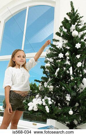 Girl decorating Christmas tree View Large Photo Image Picture - Girl decorating Christmas tree. Fotosearch