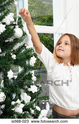 Girl decorating Christmas tree View Large Photo Image Stock Image - Girl decorating Christmas tree. Fotosearch