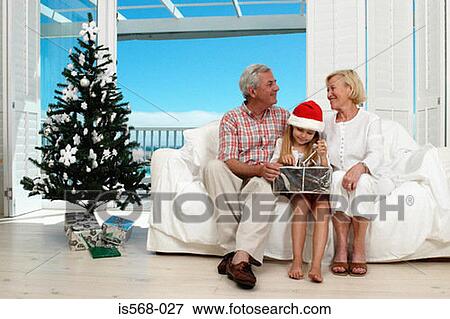 Girl opening her Christmas present View Large Photo Image Stock Photo - Girl opening her Christmas present. Fotosearch