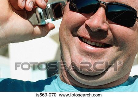 Stock Image - Double-chinned man on mobile phone. Fotosearch