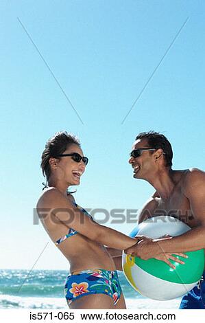 Couple playing with beach ball View Large Photo Image Stock Photography - Couple playing with beach ball. Fotosearch