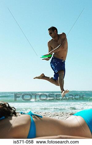 Man playing with frisbee on beach View Large Photo Image Stock Photo - Man playing with frisbee on beach. Fotosearch