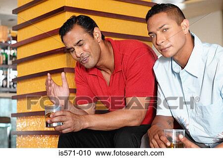 Stock Image - Two men sitting in bar. Fotosearch
