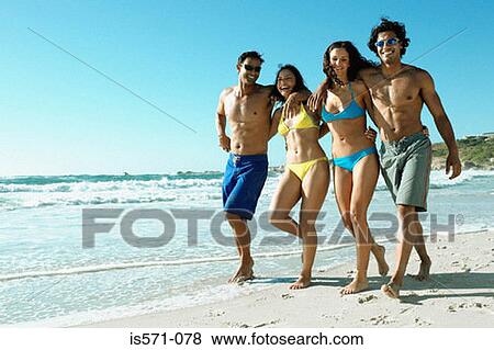 Young couples walking on beach View Large Photo Image Stock Photo - Young couples walking on beach. Fotosearch