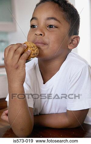 Boy eating a cookie View Large Photo Image Stock Photo - Boy eating a cookie. Fotosearch