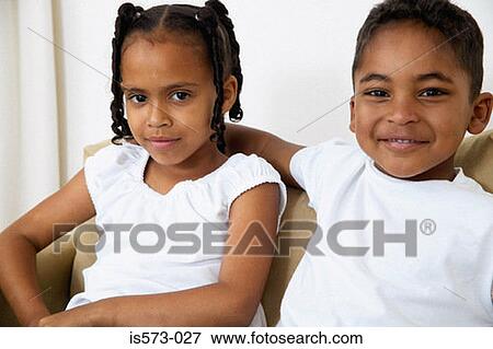 Stock Photo - Brother and sister on sofa. Fotosearch