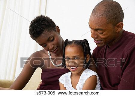Stock Photography - Family sitting on sofa. Fotosearch