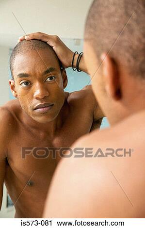 Stock Image - Man looking in mirror. Fotosearch