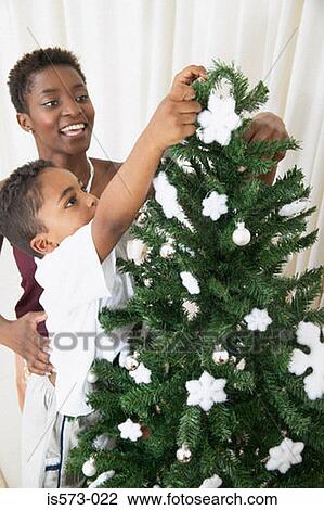 Stock Image - Mother and son decorating christmas tree. Fotosearch