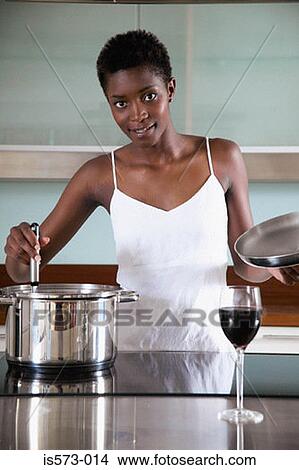 Picture - Woman cooking in kitchen. Fotosearch