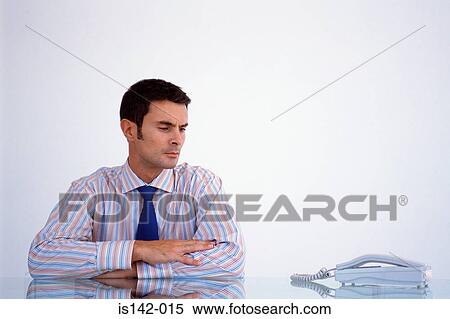 Stock Photography - Businessman looking at phone. Fotosearch