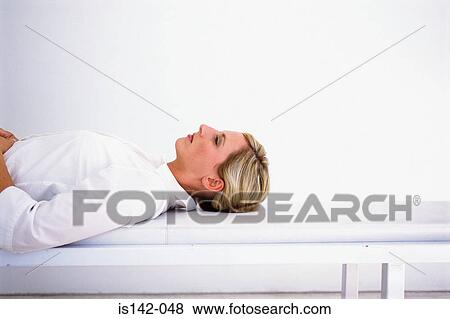 Stock Photo - Female lying down on bench. Fotosearch