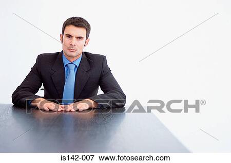 Stock Photo - Serious businessman at table. Fotosearch