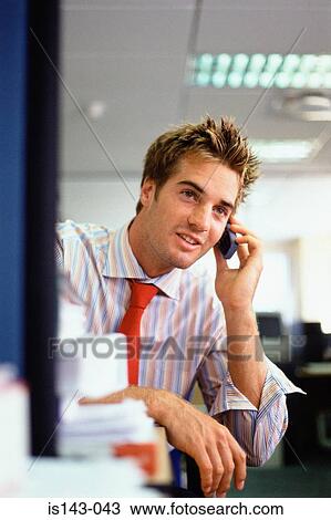 Man at desk talks on the phone View Large Photo Image Stock Image - Man at desk talks on the phone. Fotosearch